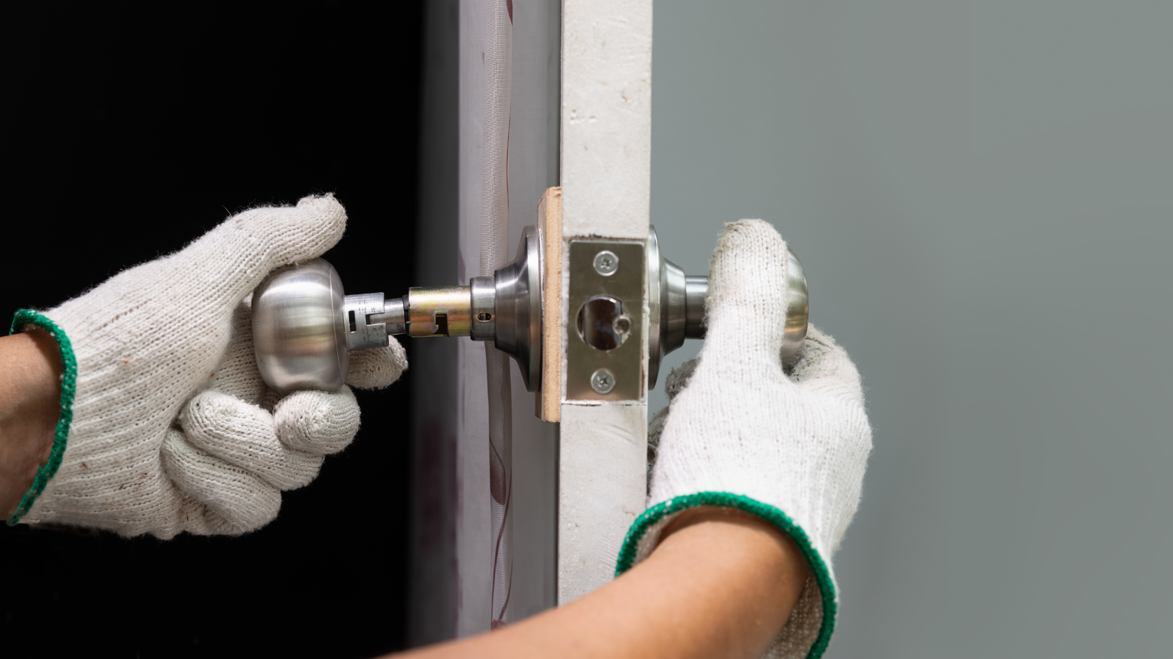 A person in white gloves is opening a door